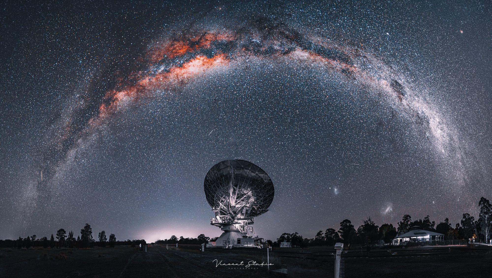 Milky Way arching over a radio telescope observatory, silhouetted against the night sky